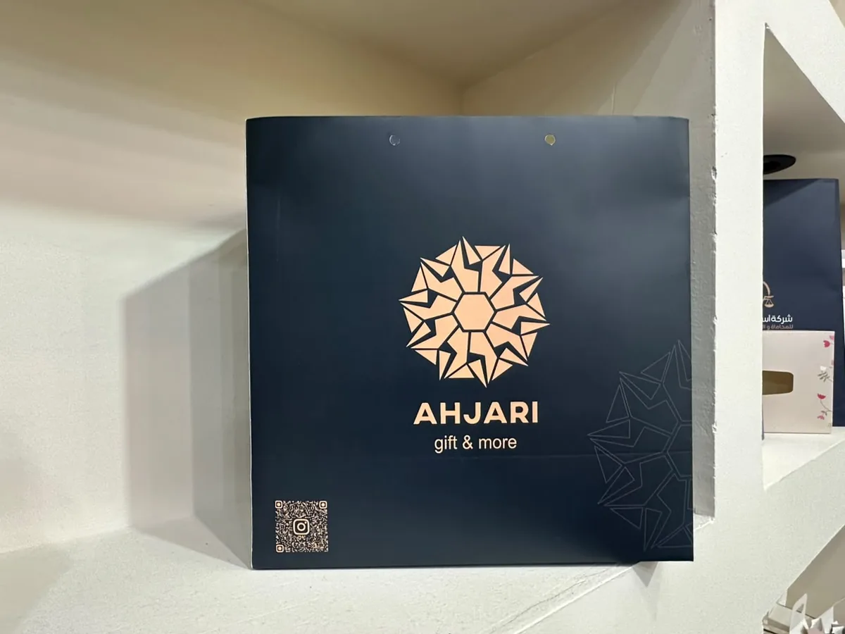 كيس ورقي فاخر بطباعة ذهبية على خلفية كحلية